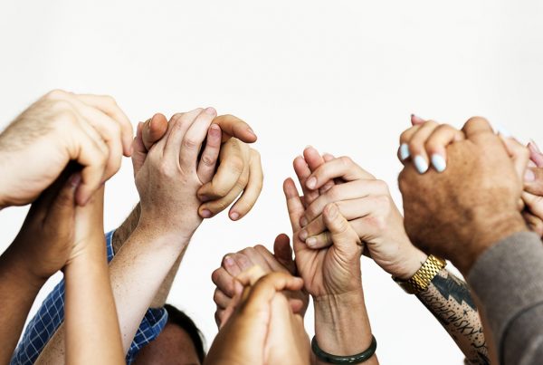 close-up of many people holding hands above their heads