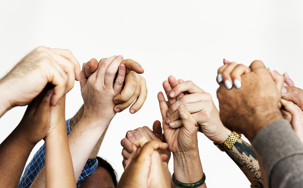 close-up of many people holding hands above their heads