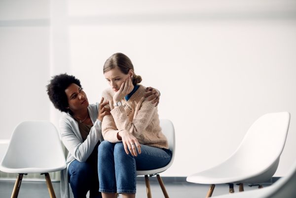 Black woman consoling a white woman in an empty room