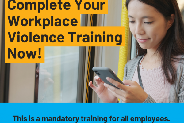 woman looking at her phone. Text reads: "Complete your workplace violence training now! This is a mandatory training for all employees."