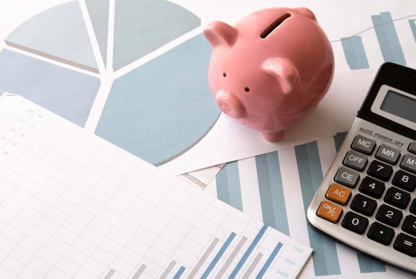 piggy bank, calculator, and financial papers on a table