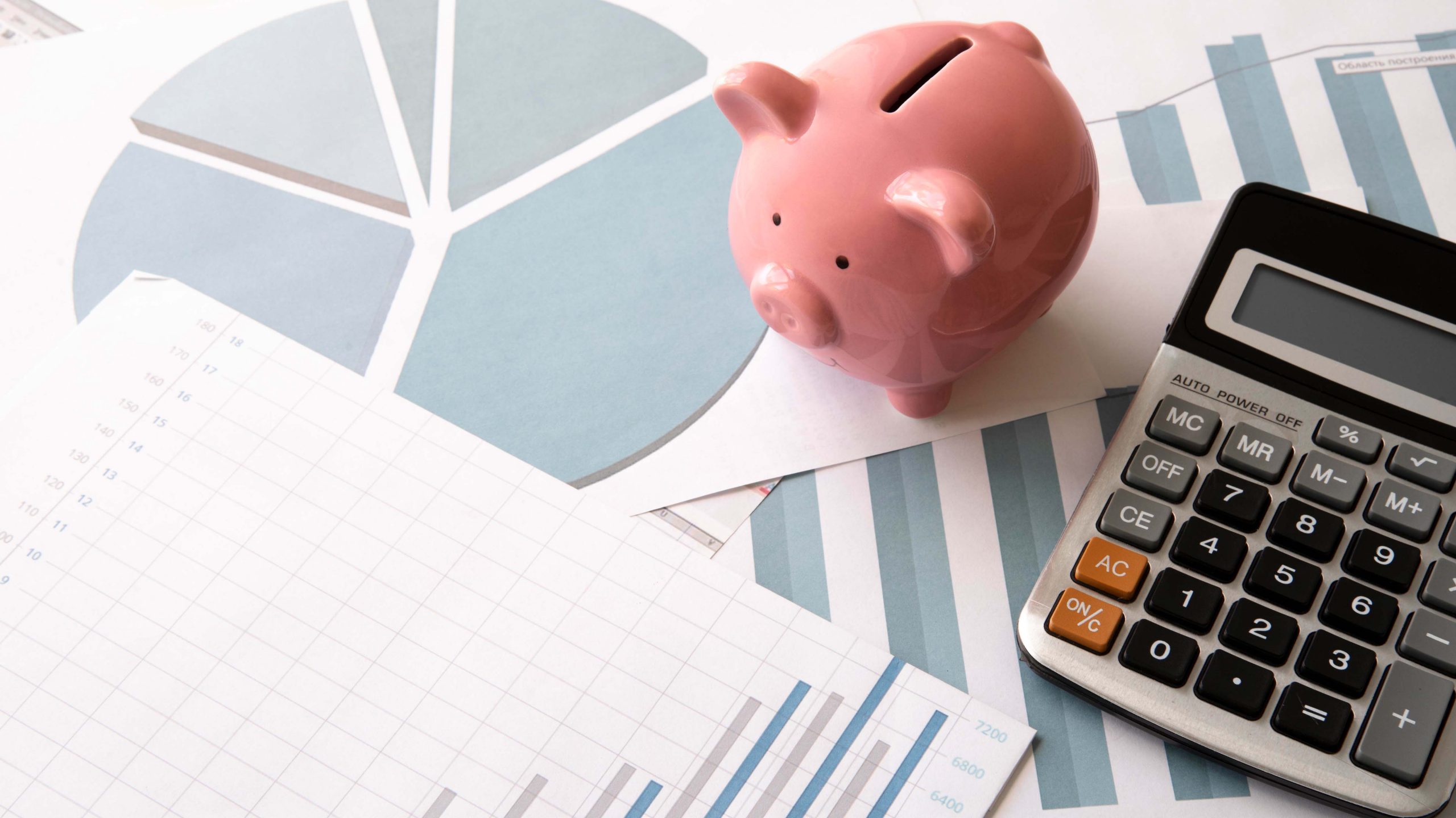 piggy bank, calculator, and financial papers on a table