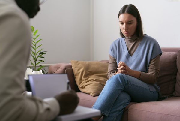 young woman who looks sad while a second person listens