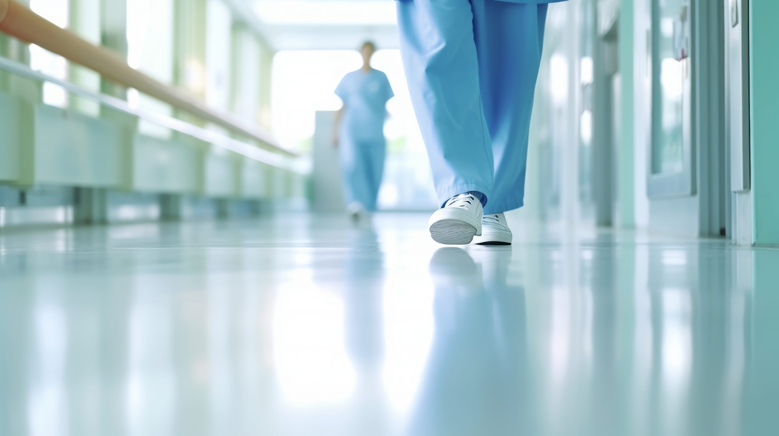 photo of person in scrubs walking, viewed from floor level