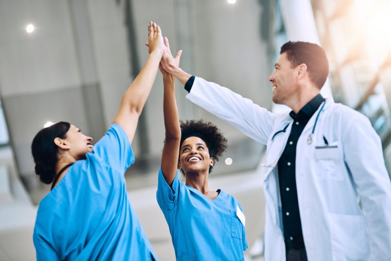 three people in scrubs high five