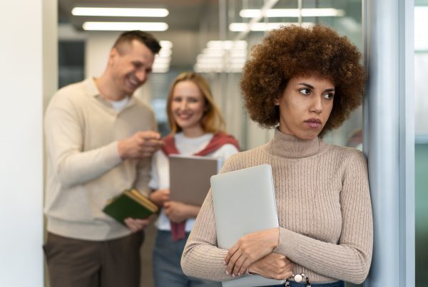 black person in the foreground looks uncomfortable while two people in the background smile