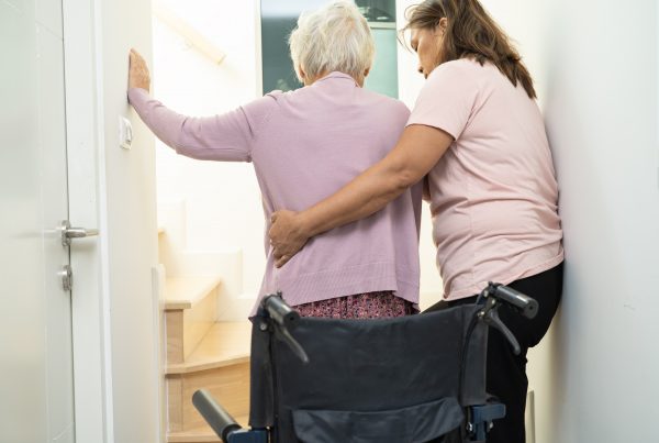 caregiver supporting a senior with a wheelchair