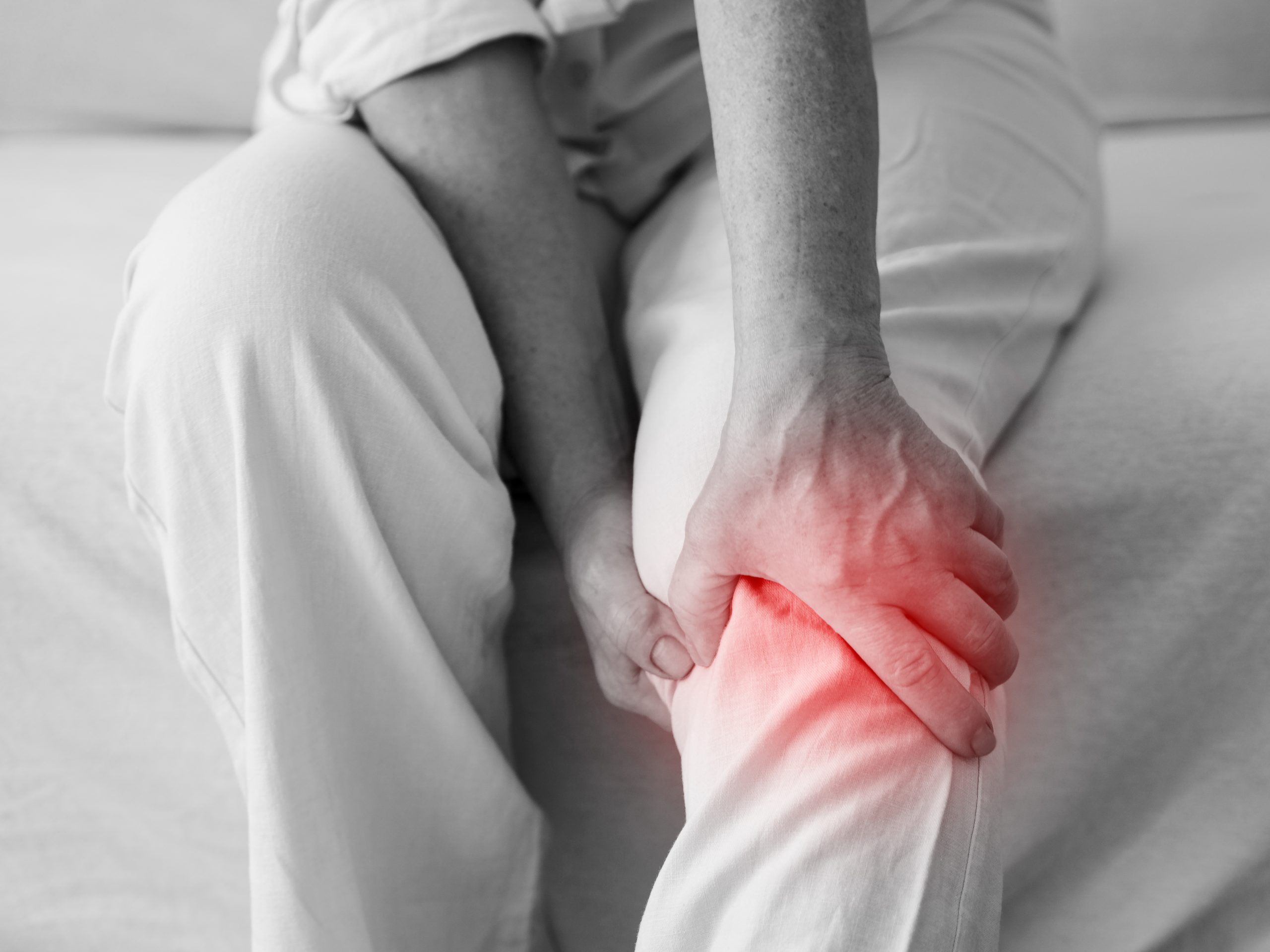 close up of a person holding their injured knee