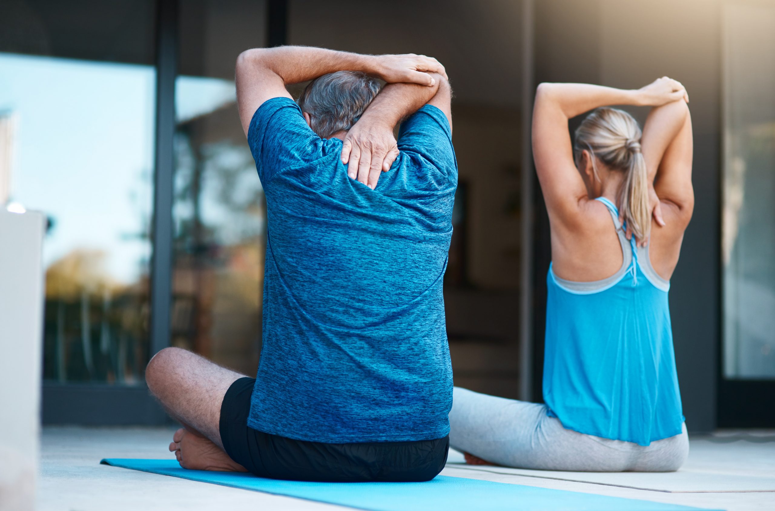 man and woman stretching back on yoga mats